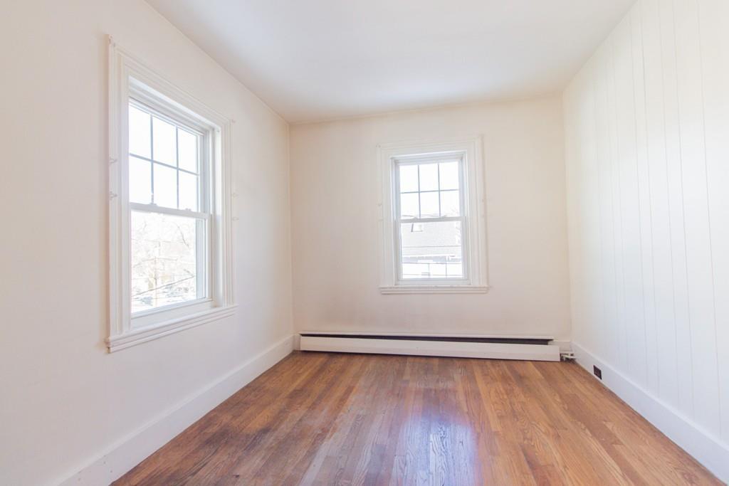 46 Eliot Crescent Brookline, MA 02467 - Photo 9 of 15 an empty room with wooden floor and windows