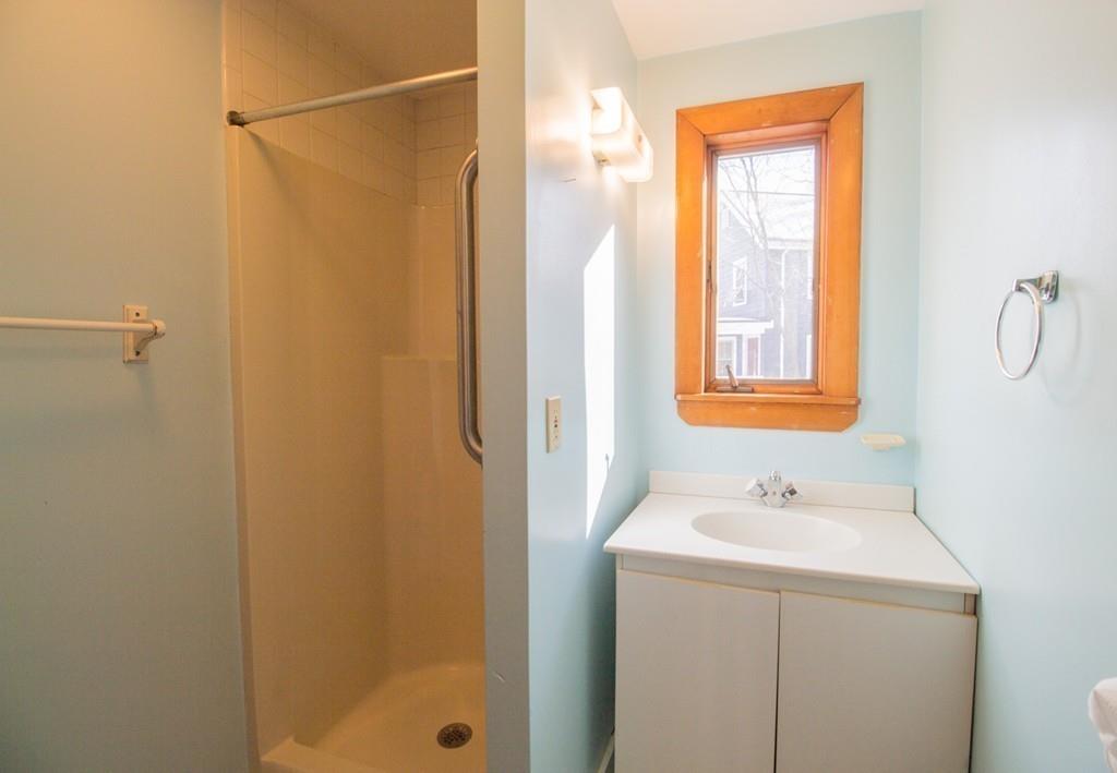 46 Eliot Crescent Brookline, MA 02467 - Photo 10 of 15 a bathroom with a sink a mirror and a shower