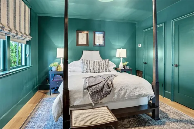 a room with painting on the wall and a wooden floor