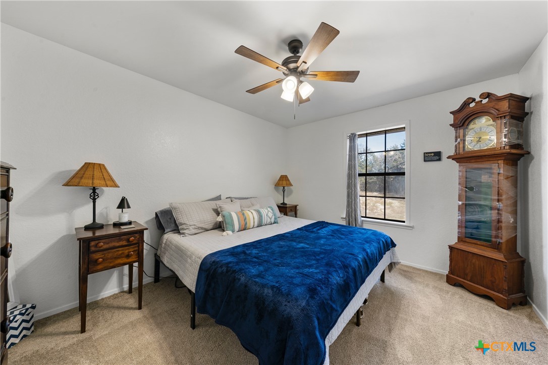 162 High Ridge Drive Bruceville, TX 76630 - Photo 20 of 35 a bedroom with a bed and a chandelier