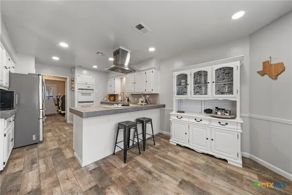 a kitchen with granite countertop white cabinets and white appliances