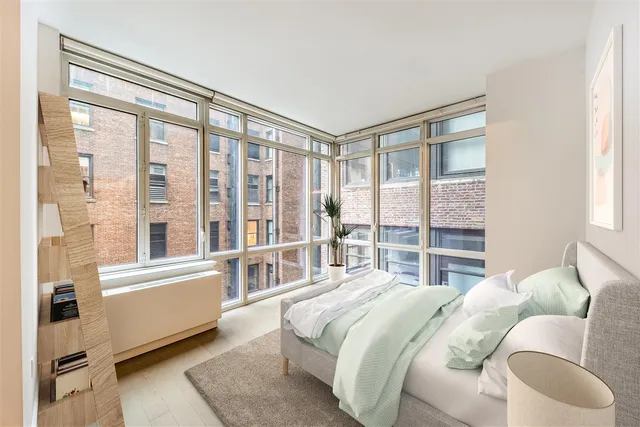 a bedroom with a bed and a large window