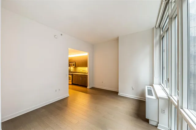 a view of a room with wooden floor and a window