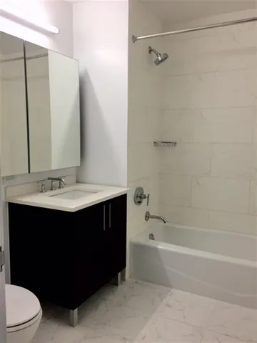 a bathroom with a sink vanity mirror and toilet
