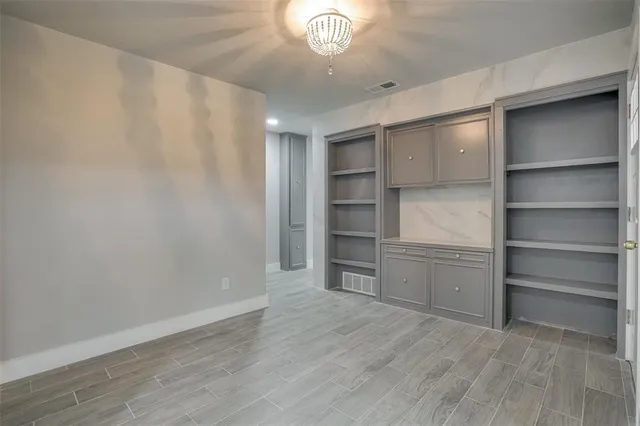 a view of a kitchen with white cabinets and a window