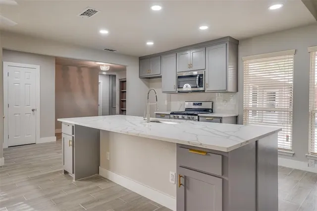 a large white kitchen with a sink and dishwasher