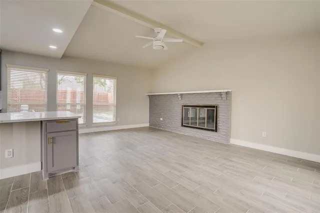 an empty room with windows and cabinet