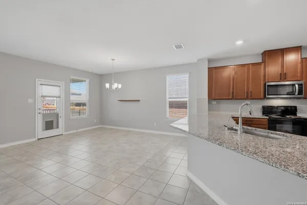 a view of kitchen with granite countertop cabinets and window