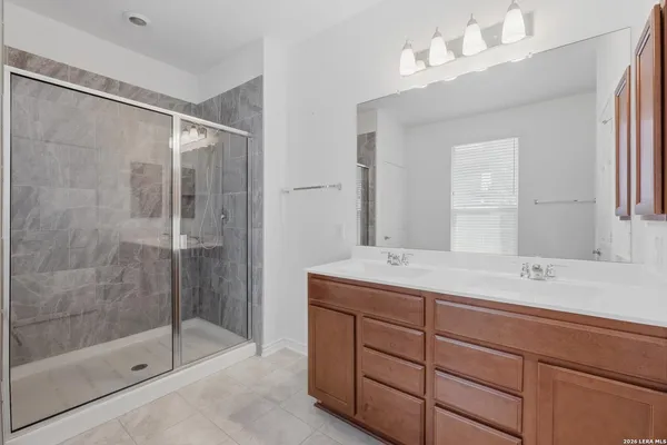a bathroom with a shower sink vanity and mirror