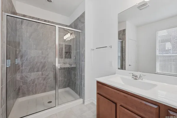 a bathroom with a shower sink and mirror