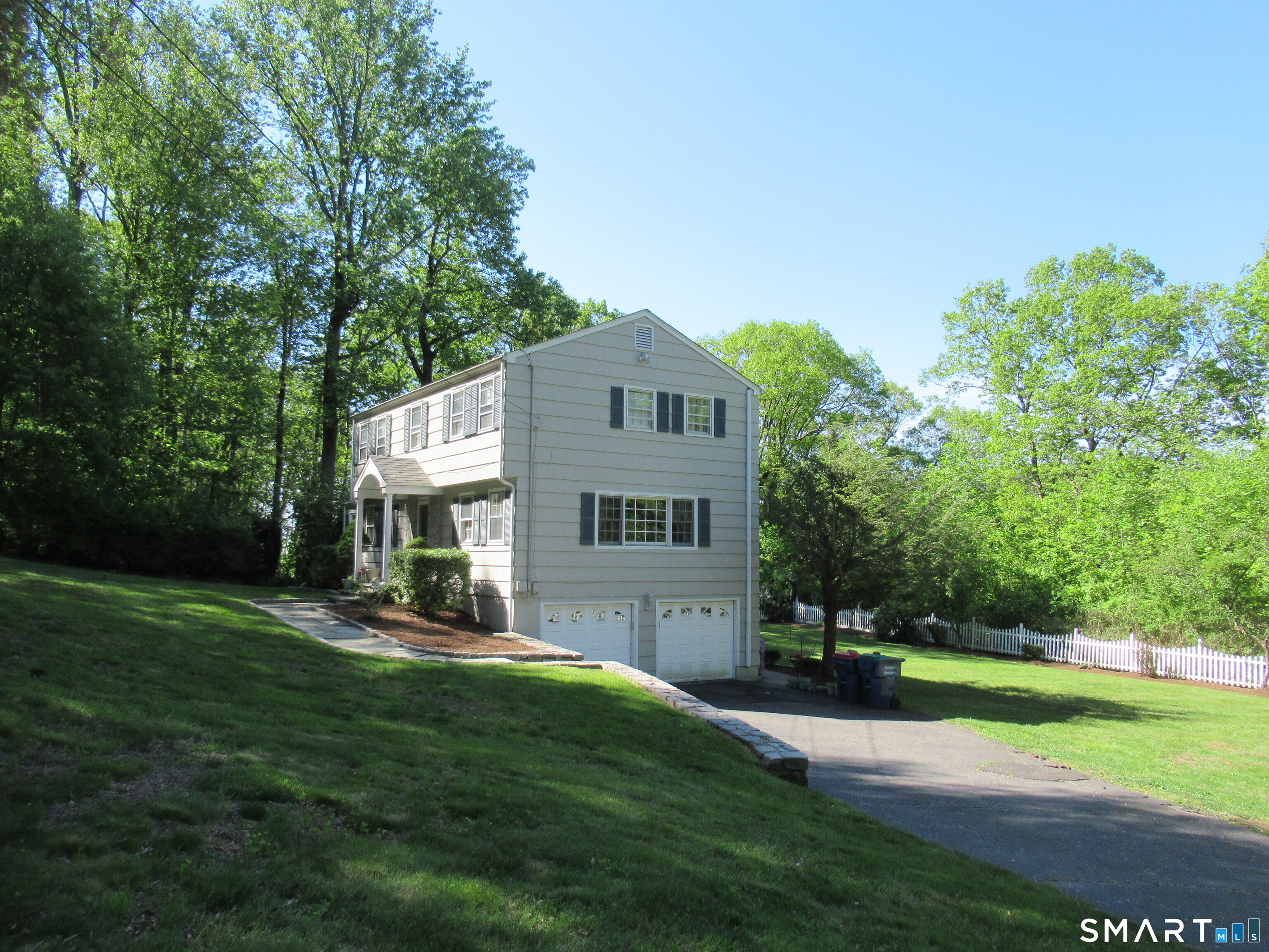 25 Shelter Rock Road Trumbull, CT 06611 - Photo 16 of 17 a front view of a house with a yard and trees