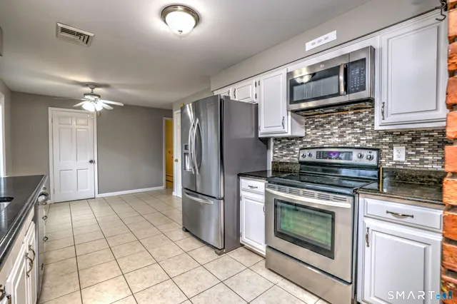 a kitchen with stainless steel appliances granite countertop a stove a refrigerator and a microwave