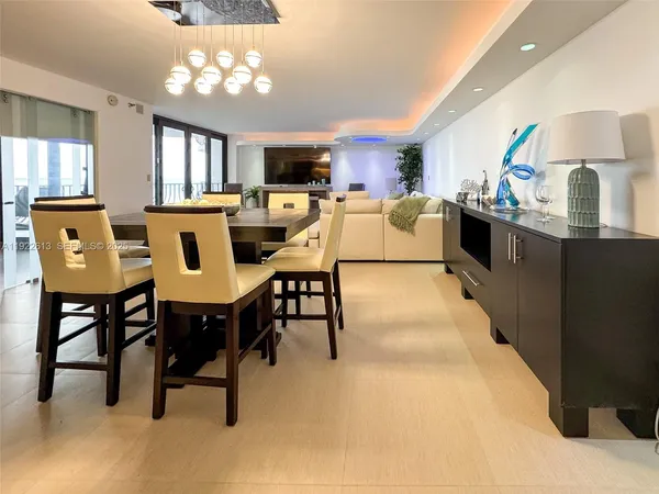 a kitchen with stainless steel appliances kitchen island granite countertop a table chairs sink and cabinets