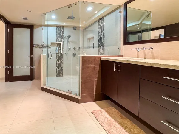 a bathroom with a shower sink and mirror
