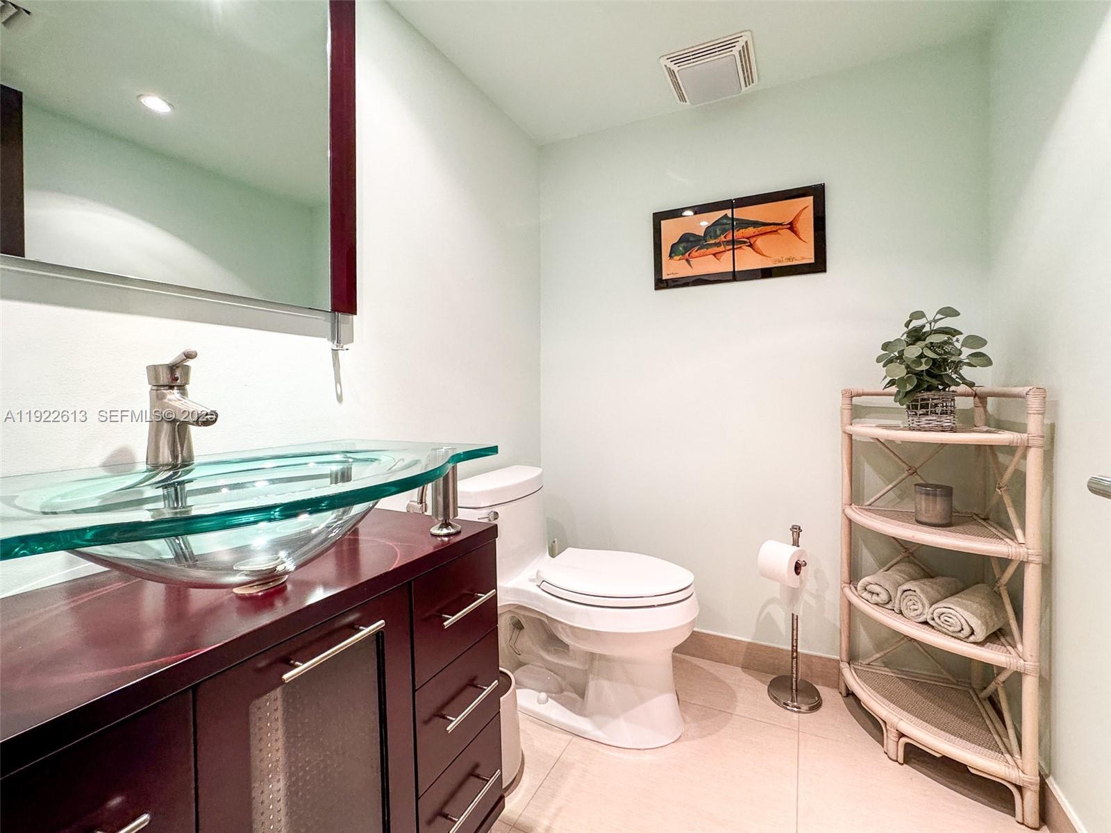 8877 Collins Avenue, Unit 809 Surfside, FL 33154 - Photo 30 of 46 a bathroom with a sink a toilet and a mirror