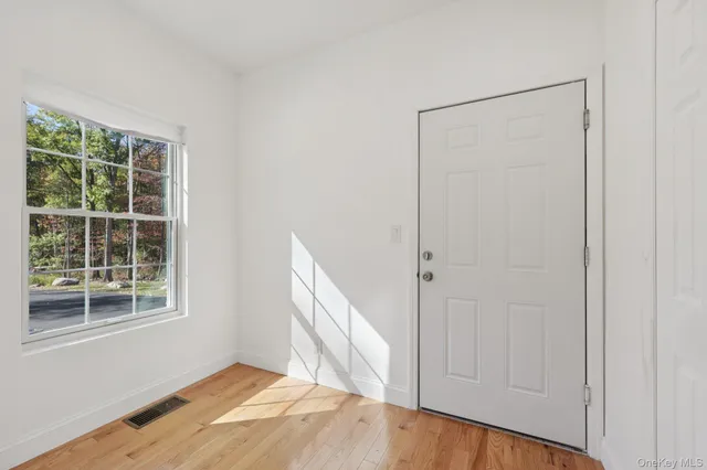 a view of a kitchen counter top space with sink and mirror