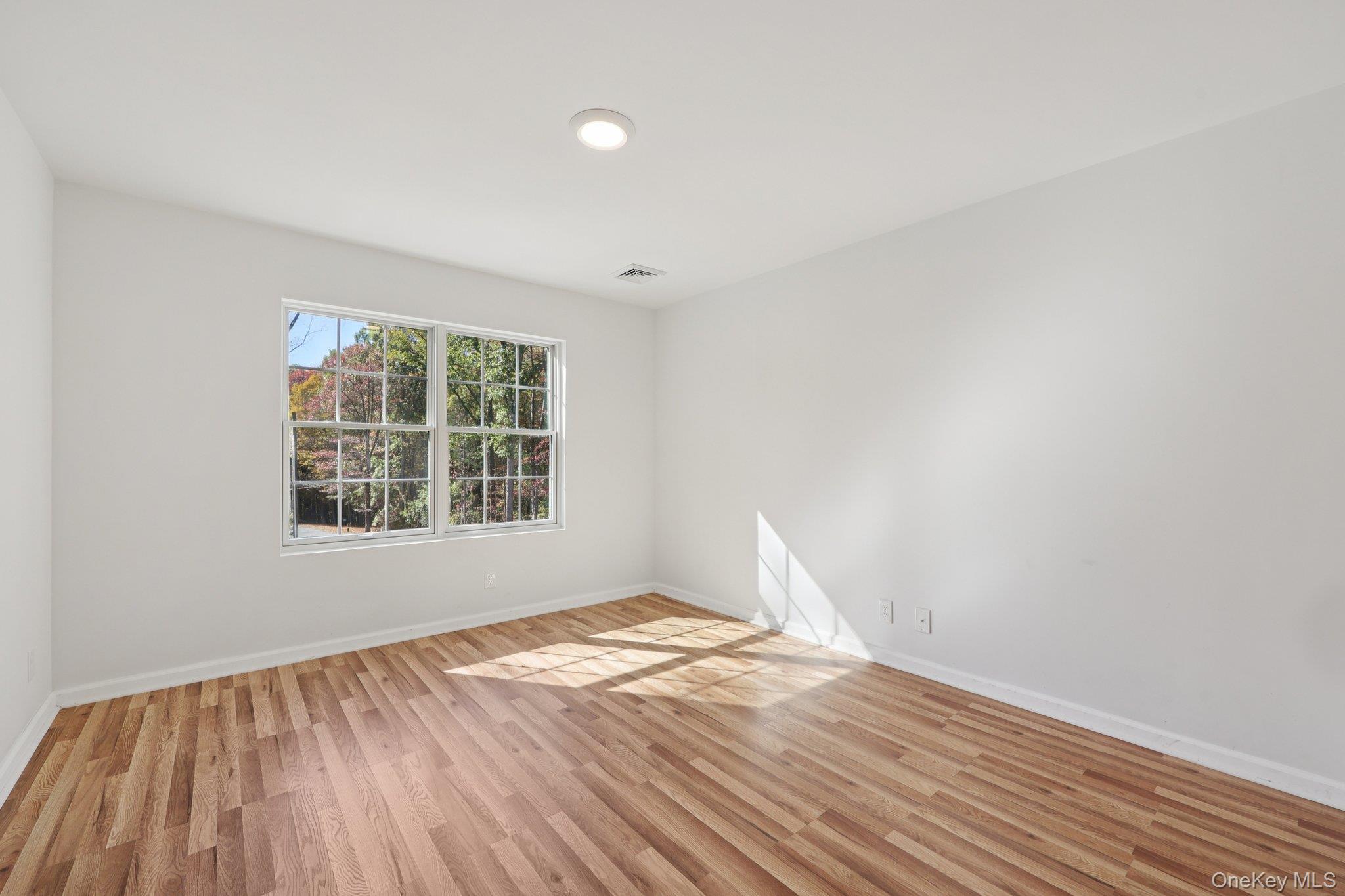 27 Oak Hill Road Monroe, NY 10950 - Photo 25 of 48 an empty room with wooden floor and windows