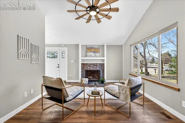a living room with furniture a fireplace and a large window