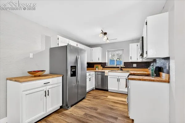 a kitchen with white cabinets and refrigerator