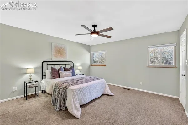 a bedroom with a bed and a ceiling fan