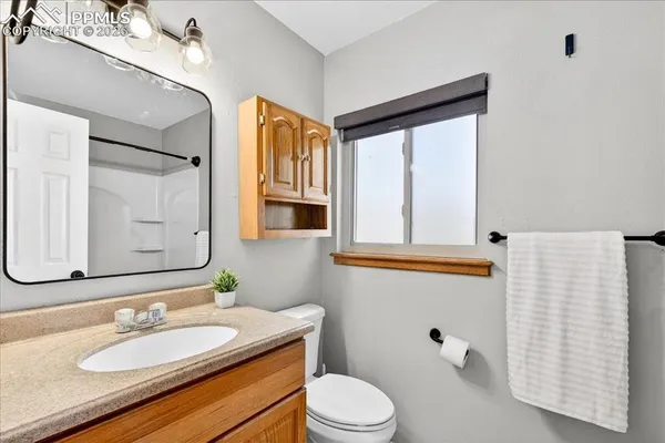 a bathroom with a granite countertop sink mirror and a toilet