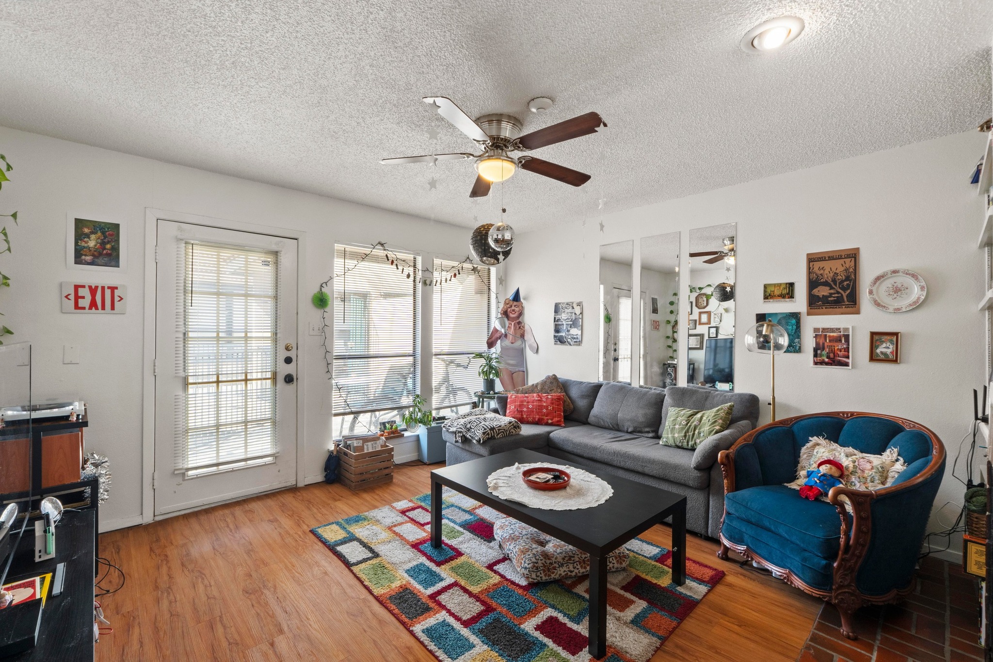 2110 Rio Grande Street, Unit 303 Austin, TX 78705 - Photo 5 of 22 Living area with a ceiling fan, light wood-style floors, and a textured ceiling