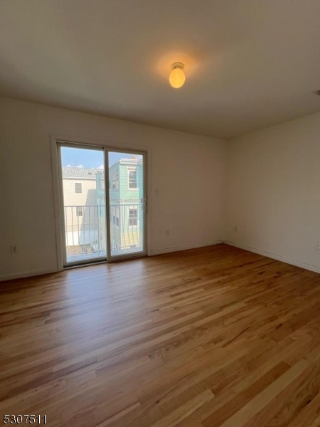 110 South 3rd Street Harrison, NJ 07029 - Photo 5 of 7 a view of an empty room with wooden floor and a window