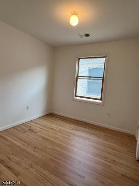 110 South 3rd Street Harrison, NJ 07029 - Photo 6 of 7 a view of an empty room with wooden floor and a window