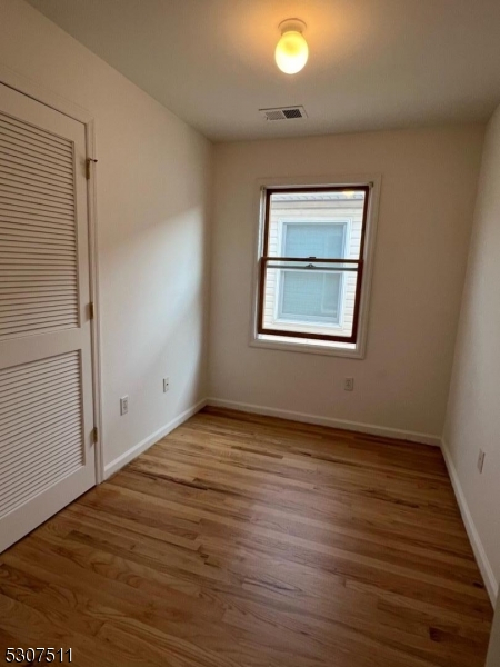 110 South 3rd Street Harrison, NJ 07029 - Photo 7 of 7 an empty room with wooden floor and windows