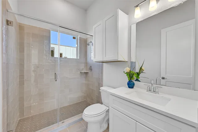 a bathroom with a sink a toilet and shower