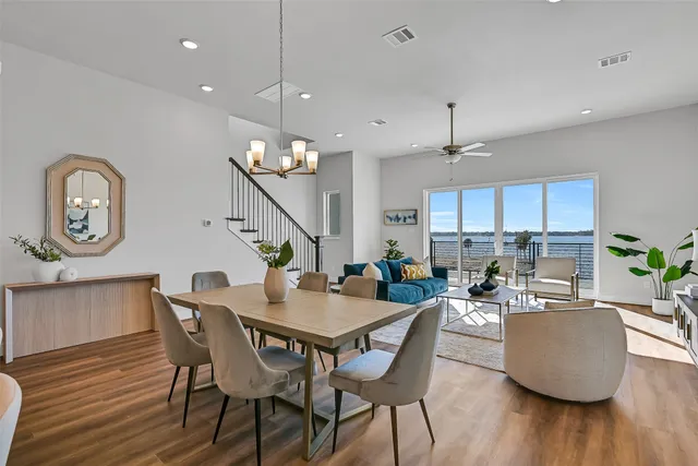 a view of a dining room with furniture a chandelier and wooden floor