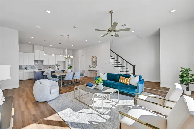 a living room with furniture kitchen view and a chandelier