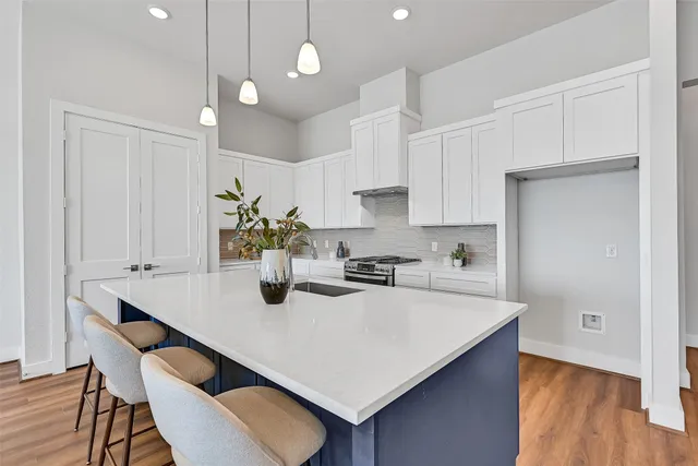 a kitchen with kitchen island a stove a table and chairs