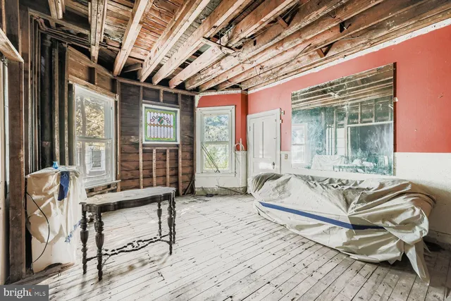 a bed sitting in a spacious bedroom next to a window