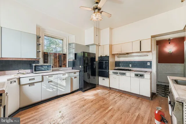 a kitchen with a sink cabinets stainless steel appliances and a window