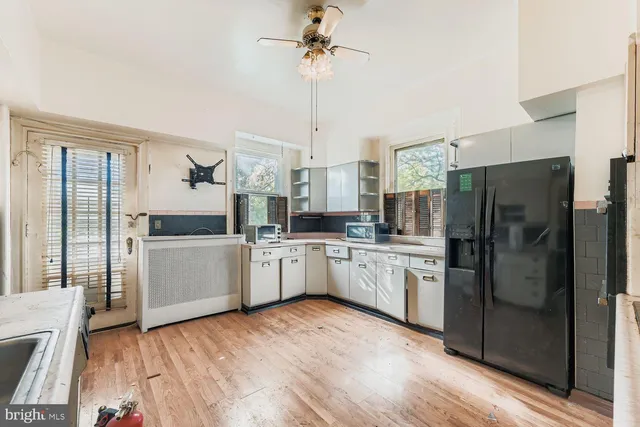 a kitchen with refrigerator cabinets and wooden floor