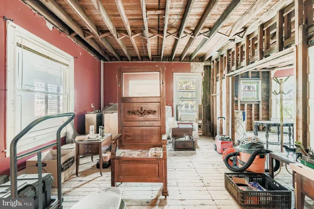 a living room with furniture a rug kitchen view and large windows