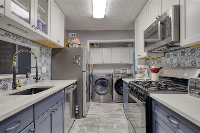 a utility room with sink dryer and washer