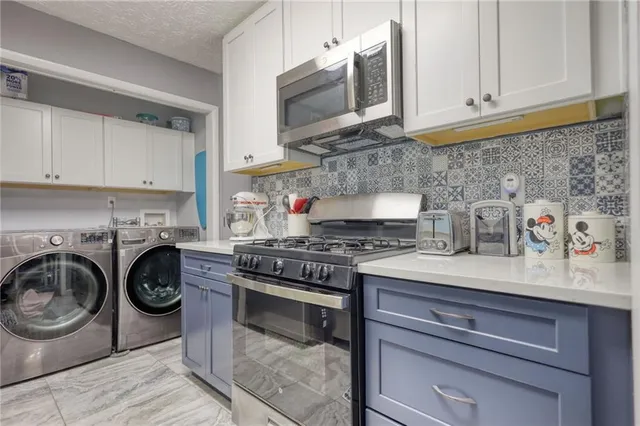 a kitchen with stainless steel appliances granite countertop a stove and a white cabinets