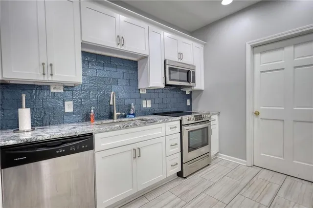 a kitchen with cabinets stainless steel appliances and sink
