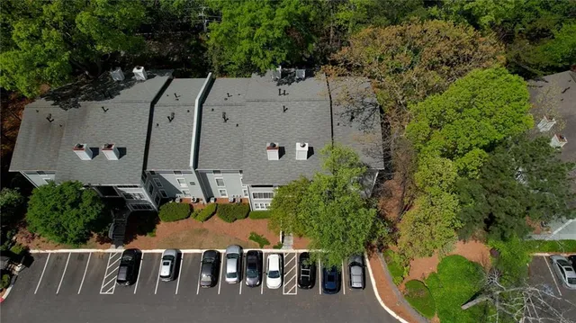 an aerial view of a house with outdoor space and trees all around