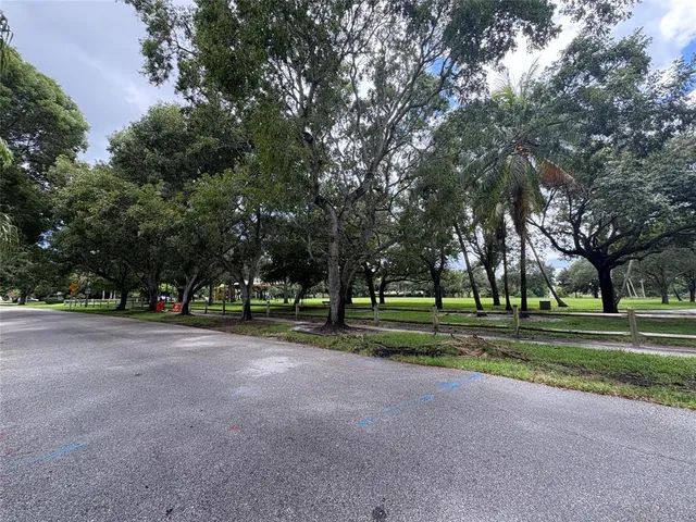 a view of a house with a big yard and large trees