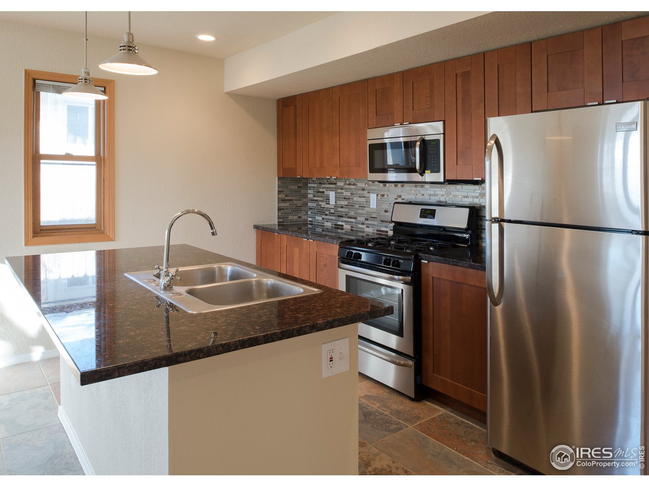 2535 Spruce Street Boulder, CO 80302 - Photo 5 of 17 a kitchen with stainless steel appliances granite countertop a refrigerator a stove a sink dishwasher and microwave