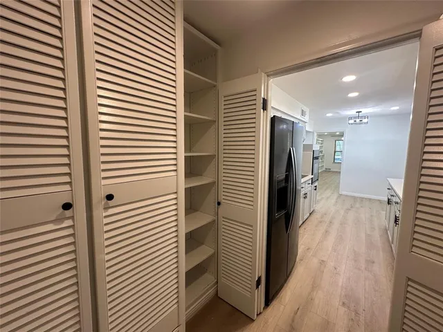 a view of a hallway with a kitchen