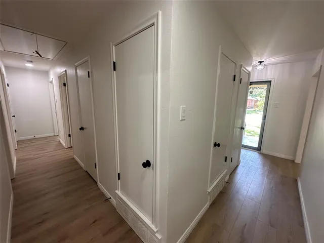 a view of a hallway with wooden floor