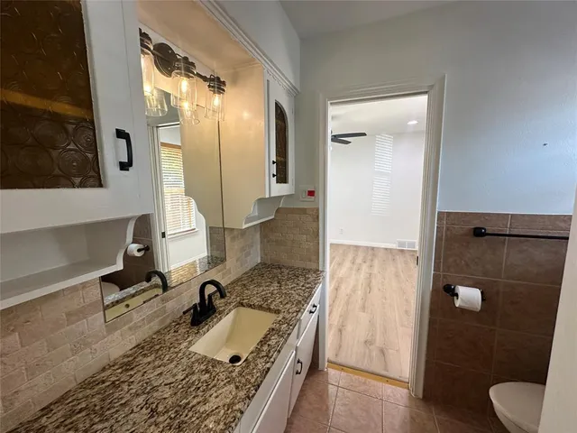 a bathroom with a granite countertop sink a mirror and shower