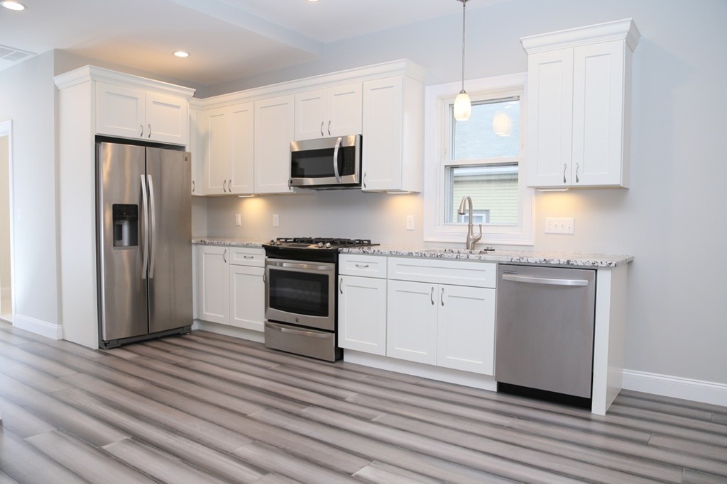 56 Byron Street, Unit 2 Boston, MA 02128 - Photo 2 of 17 a kitchen with a white cabinets and stainless steel appliances