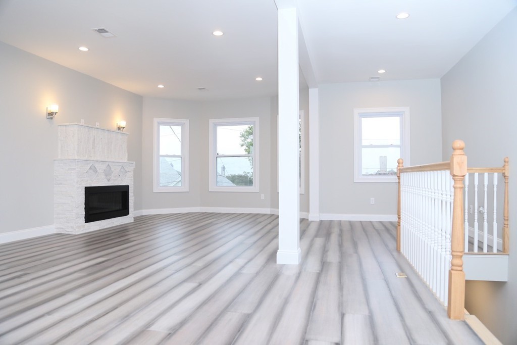 56 Byron Street, Unit 2 Boston, MA 02128 - Photo 5 of 17 a view of empty room with wooden floor and fireplace