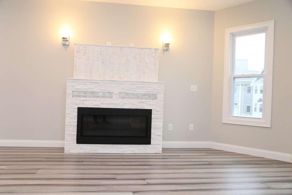 56 Byron Street, Unit 2 Boston, MA 02128 - Photo 6 of 17 a view of a livingroom with a fireplace and wooden floor