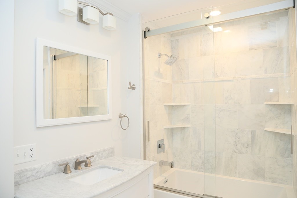 56 Byron Street, Unit 2 Boston, MA 02128 - Photo 8 of 17 a bathroom with a granite countertop bathtub shower sink vanity and toilet